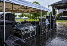 Como Proteger Equipamentos em Eventos Externos Equipamentos de som e iluminação protegidos por tenda em evento ao ar livre com cobertura contra chuva e umidade